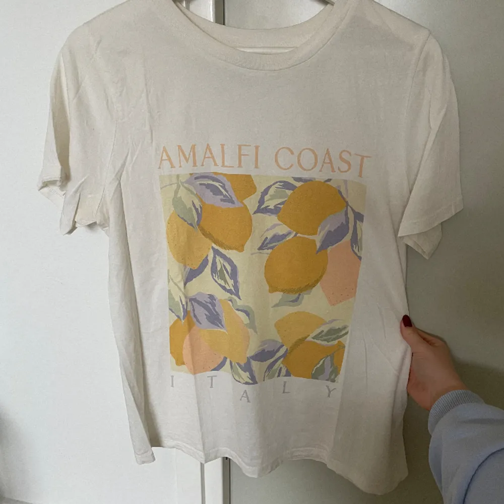 Somrig tshirt från Gina tricot. Knappt använd. Italiens Amalfi kust-text på framsidan med citroner. Väldigt somrig och fin! . T-shirts.