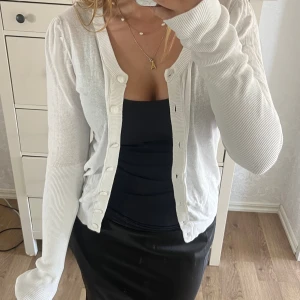 Vit kofta  - Hej, jag säljer en jättesöt kofta med vita knappar. Koftan är knappt använd och i bra sick💕den är väldigt liten i storleken. Koftan är i storlek L men skulle mer säga att koftan är i storlek S, (passar M-XS)😇