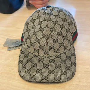 Gucci keps  - Jag säljer nu min Gucci keps då jag är i behov av pengar kan gå ner lite i pris men inte mycket den är i bra sick och sitter som s fast den är i m,kan byta mot en tiger keps i storlek s som är äkta,har inget kvitto eller box 
