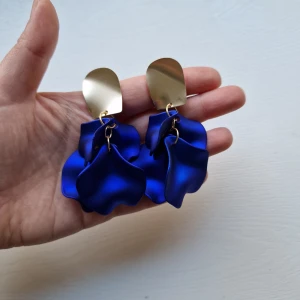 Örhängen blomblad rosblad lövblad blå guld - Jättefina nya örhängen i guldfärgad metall och "blomblade" i royalblue. Så fina och lyxiga!  Helt oanvända! Väldigt trendiga!  