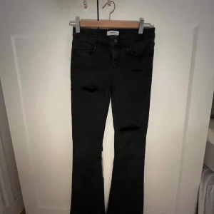 Svarta bootcut jeans med slitningar - Snygga svarta bootcut jeans med själv klippta hål