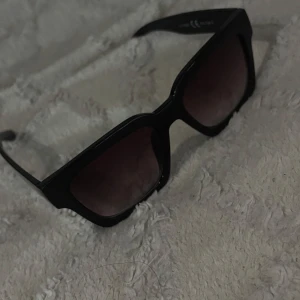 Svarta solglasögon från Runsven - Snygga svarta solglasögon från Runsven med breda bågar och fyrkantig form. Glasen är mörka och ger en cool vibe till din look. Perfekta för soliga dagar och när du vill sticka ut lite extra.