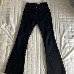 Svarta bootcut jeans från Gina Tricot - Snygga svarta bootcut jeans från Gina Tricot i modellen Perfect Jeans. Jeansen har klassisk femficksdesign, normalhöjd midja och är tillverkade i ett stretchigt bomullsmaterial. Perfekta för dig som gillar en tidlös och trendig look. Köpare står för frakt.