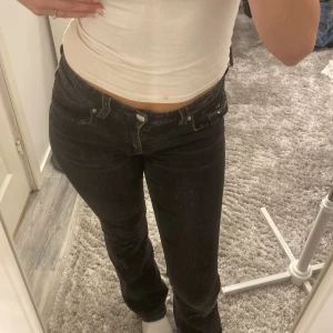 Svarta bootcut jeans med låg midja - Säljer ett par svarta jeans med bootcut-modell och låg midja. Även med fickor där bak!