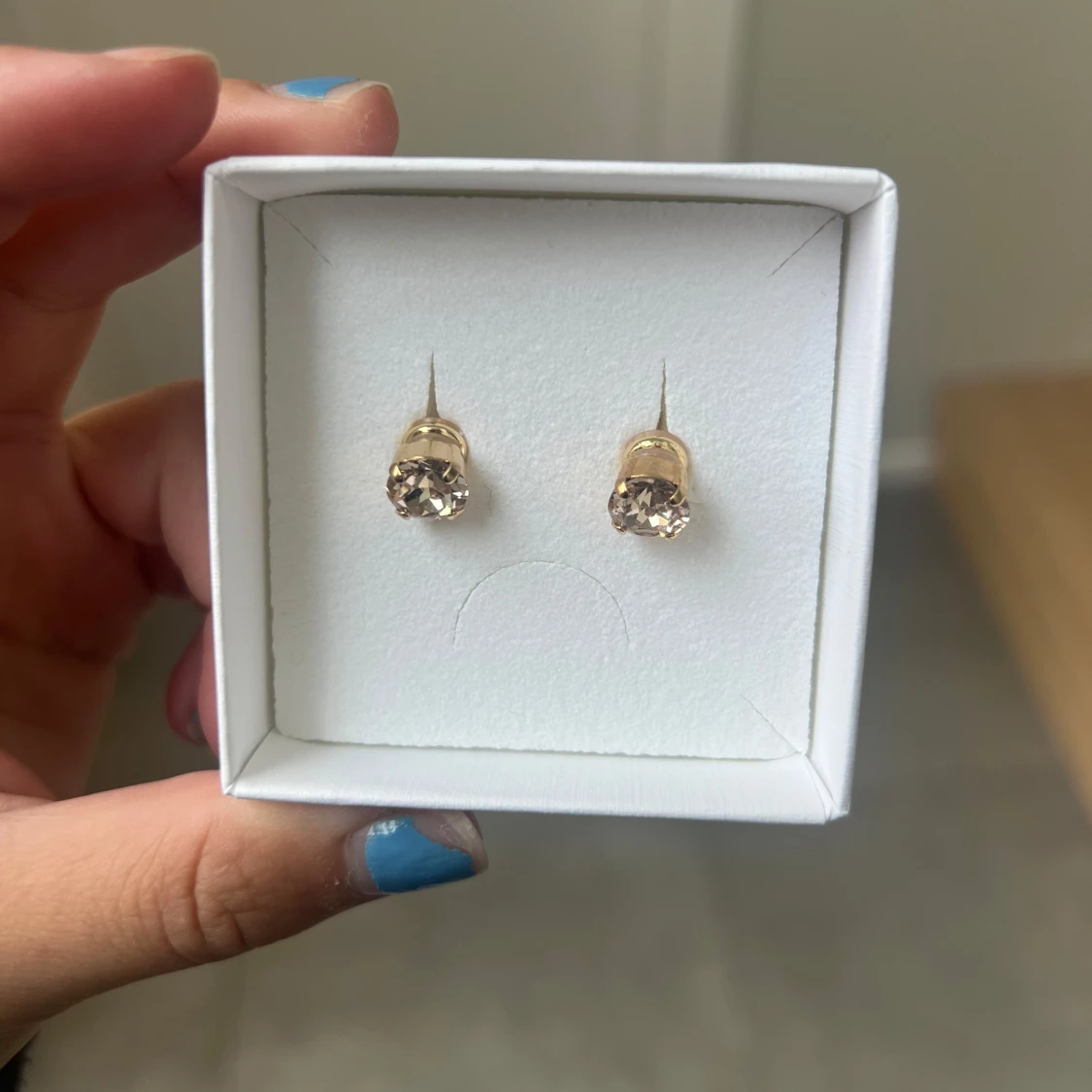 Guldiga örhängen med ljusa stenar - 1