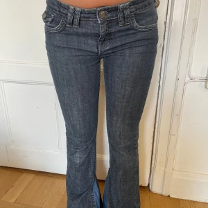 Mörkblå bootcut jeans med fickdetaljer - Snygga mörkblå jeans med bootcut passform och låg midja. Jeansen är omsydda vid fötterna med en annan jeans-färg!
