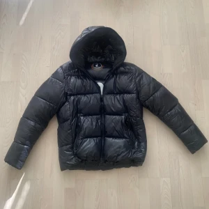 Save the Duck Jacka  - Tjena! Säljer nu min tvärfeta glansiga jacka från märket Save the Duck i storlek L. Jackan är knappt använd och därav iprincip i nyskick! Priset är ej hugget i sten så hör av dig vid minsta fundering:)