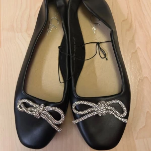 Ballerinaskor - Helt nya gulliga svarta ballerinaskor med rosett i strass. Storlek 36🌺kom med prisförslag, allt ska bort!!