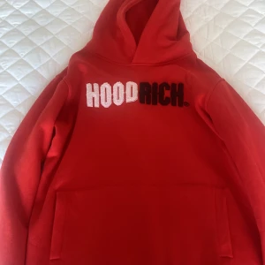 Röd hoodie från Hoodrich XL - Säljer en röd hoodie från Hoodrich i storlek XL för tonåringar. Tröjan har stor huva, magficka och broderad HOODRICH-logga i vitt och svart på bröstet. Mjuk insida och klassisk streetwear-look, perfekt för chill dagar. Passar dig som gillar bold färger och enkel stil.
