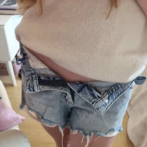 Ljusblå jeansshorts - Säljer ett par blå jeansshorts från Gina Tricot i storlek 158 (motsvarar ca 12–13 år). Shortsen är använda men välskötta, inga hål eller fläckar. Klassisk modell som passar till allt! (Är snäppet mörkare än på bilden då den är tagen med blixt, du kan alltid fråga om mer bilder.) Köp direkt via Plick! Snygga och kan stylas på flera olika sätt inför sommaren! Nypris runt 200 kr! Medelhög midja, se bild!