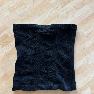 Svart bandeau tubtopp med mönster - Svart bandeau tubtopp med snyggt strukturerat tyg och diskret mönster. Helt oanvänd💕
