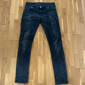 Nudie jeans Grim Tim W30 L32  - Säljer dessa mörk gråa nudie jeans i modellen grim Tim. De är väl använda men i bra skick. De är en smalare passform i en populär modell. Priset är justerbart vid snabb affär😊