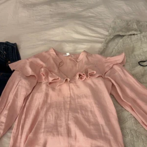 Rosa blus från hm - Säljer en rosa blus med volanger från HM i storlek xs använd fåtal gånger