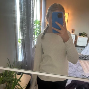 Beige stickad tröja från Vero Moda - Mysig beige stickad tröja från Vero Moda i storlek XS. Tröjan har rund hals, ribbade muddar vid ärmslut och nederkant samt långärmad passform. Perfekt för dig som gillar enkel och clean stil med en neutral färgton.