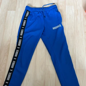 Blå Hoodrich  - Snygga blå mjukisbyxor från Hoodrich. Byxorna har elastisk midja med dragsko och sidofickor. Perfekta för chill eller streetwear, med tydlig och riktigt Hoodrich branding på benet och framtill.  Helt ny och aldrig använd!🤩