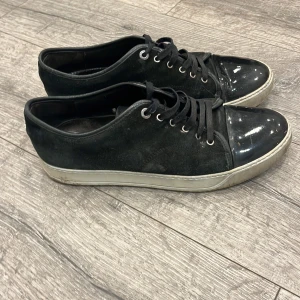 Lanvin captoe - Svarta sneakers med snygg kontrast mellan mocka och glansig lackad tå. Klassisk snörning och vit sula ger en clean look. Perfekta för dig som gillar stilrena skor med en twist. Lavin cap toe i Storlek 45