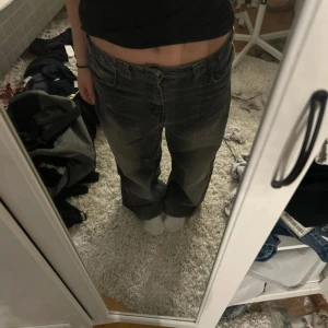 Grå baggy jeans från Bershka - Säljer ett par gråa baggy jeans från Bershka i storlek 38. De har en cool tvättad look med ljusare partier och klassisk femficksmodell. Jeansen har låg midja och raka, lösa ben.
