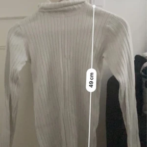 KÖP PÅ FRÅN MIN VINTED - Snygg vit polotröja med ribbat mönster och lång ärm. Tröjan har en tight passform och hög hals, perfekt att styla med jeans eller kjol. Enkel och stilren design som funkar till många olika looks.