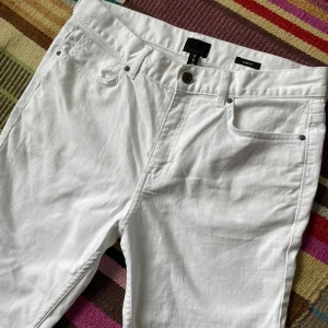 Vita skinny jeans från H&M - Snygga vita jeans från H&M i klassisk femficksmodell. Byxorna har smal passform och normal midja, perfekta till sneakers eller boots. Materialet är mjukt och stretchigt för extra komfort. Enkla att matcha med allt i garderoben.