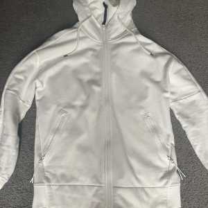 Vit hoodiejacka med goggles från C.P. Company - Säljer en clean vit hoodie från C.P. Company med deras ikoniska goggles i huvan.  9/10 i skick, använd runt tio ggr. Nypris: 3400