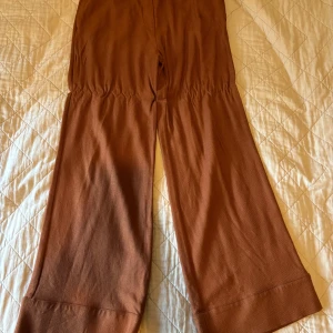 Bruna wide byxor från A Part of the Art - Snygga bruna byxor från A Part of the Art med breda ben. Knappt använda nypris ca 1200