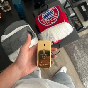 Paco Rabanne 1 Million EdT 50ml - 1 Million från Paco Rabanne är en ikonisk herrparfym i en lyxig guldfärgad flaska som påminner om en guldtacka. Flaskan är tillverkad i metall och plast, med eleganta detaljer och en modern, maskulin design. Doften är känd för sin fräscha, kryddiga och varma karaktär. i princip hela kvar (kolla andra bild!)