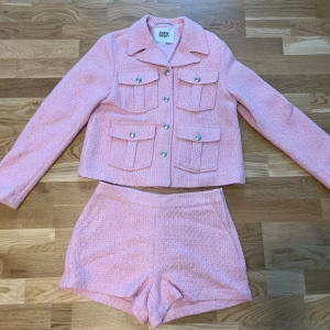 Twist & Tango rosa set - Märke: Twist & Tango Shorts: storlek 36 Blazer: storlek 36 Nyskick Övrig info: shortsen har fickor, man stänger shortsen med en dragkedja och knäppning på sidan (se bild nr 3-4). Nypris för blazer: 2299kr Nypris för shorts: 1199kr