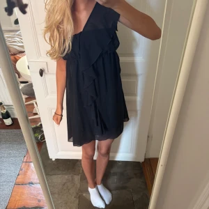 Svart kort volangklänning - Supersöt svart kortklänning med volangdetaljer framtill. 💕