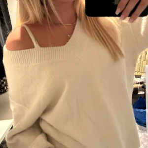 Offshoulder vit stickad tröja - Supermjuk och oversized vit stickad tröja med bred ribbad kant vid halsen. Sitter snyggt offshoulder och har långa, lite vidare ärmar. Perfekt för lager-på-lager och chill vibes.