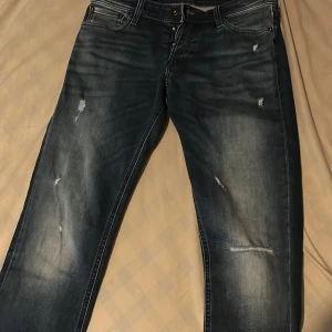 Mörkblå slitna jeansbyxor 31/34 - Säljer ljus blå jeans från Jack and Jones där den är även oandvänd. Pris kan diskuteras