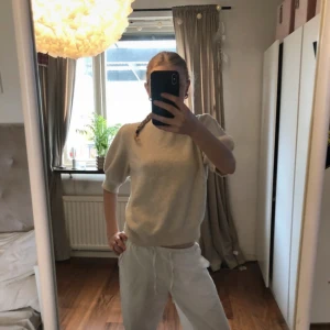 Beige stickad tröja med kort ärm - Supermjuk beige stickad tröja med korta ärmar och ribbade muddar. 