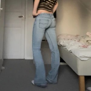 Blå bootcut jeans med nitar och slitningar  - Säljer mina absoluta favoritjeans då de tyvärr blivit försmå😔De är assnygga, bootcut, lågmidjade och unika med nitar! Då de är så pass använda har de även rätt många defekter. De har hål i knät, innersida lår, ca 2 hål vid hällor och en nit saknas! Defekterna kom även från förra ägaren. Jag anser att hålen är lättfixade och inte påverkar utseendet så mycket, dvs det är fof assnygga! Skriv om ni vill ha bild på alla defekter❤️Midja: ca 39. Innerbenslängd: ca 85. Älskar byxorna därav priset!🥹