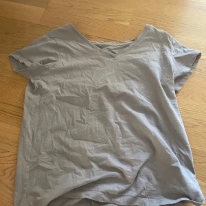 beige basic t-shirt från Basic You - Enkel och stilren beige t-shirt från Basic You i ekologisk bomull. T-shirten har v-ringning och korta ärmar, perfekt för en clean och avslappnad look. Passar dig som gillar basic plagg med skön passform.