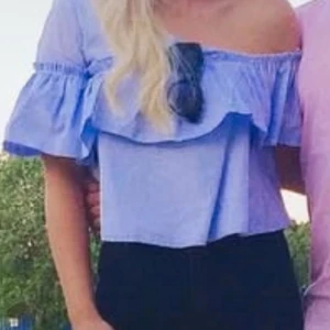 Blå offshoulder blus med volang - Säljer en söt blå offshoulder blus med volangdetaljer. Blusen har ett randigt mönster och korta ärmar. Perfekt till sommaren💕🩷🌸