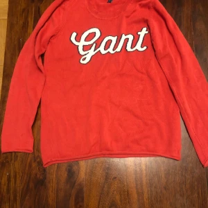 Röd tröja från Gant - Säljer en snygg röd tröja från Gant med deras logga i vitt på framsidan. Tröjan har långa ärmar och en rund halsringning. Perfekt för en stilren och avslappnad look.