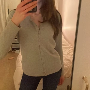 Grå kofta från Saint Tropez - Säljer en stilren grå kofta från Saint Tropez. Den har långa ärmar och knappar framtill, perfekt för en avslappnad look. Passar bra till både jeans och kjol. Perfekt för kyligare dagar!