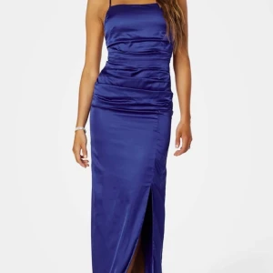 Blå balklänning  - Säljer min blåa balklänning med smala axelband och en slits framtill. Klänningen har en åtsittande passform och korsade band i ryggen. 