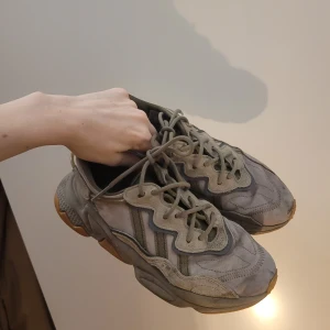 Sneakers från Adidas - Säljer ett par grå sneakers från Adidas med en chunky sula och snörning. Skorna har en unik design med vågiga detaljer och en kombination av olika grå nyanser. Perfekta för en avslappnad stil.