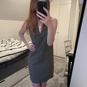 Grön klänning  - Säljer en stilren grön klänning från La Redoute. Klänningen har en v-ringad design och är ärmlös, vilket gör den perfekt för varmare dagar.💚