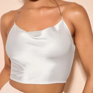 Satin topp - En söt satin topp med kedja rund halsen som är jätte fin till exempelvis midsommar, använd fåtal gånger och har inga synliga defekter. Har tyvärr inga bilder med den på.