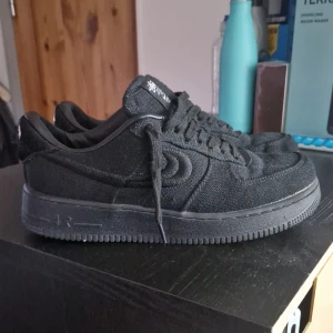 NIKE X STÜSSY AF1 - Snygga svarta sneakers från Niken och stüssy med en stilren design. Lite starloss på dem men annars stilrena. Använda 3 gånger