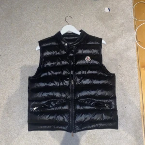 Moncler väst  - Västen är äkta köpt ungefär 1år sen har inget og kvar scan funkar den är jätte fin skick 9/10 inga defekter storlek 2=M/S Nypris 9299kr skriv om fler bilder och bilder på Scan man får med NK påsen 
