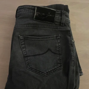 Jacob cohen - Snygga svarta jeans från Jacob Cohen, modell Type 622. De har en klassisk femficksdesign och knappar i gylfen. Perfekta för en stilren look. Dem har ett hål vid gylfen därav priset, går lätta att fixa genom att sy själv eller lämna in hos skräddaren! Priset är inte hugget i sten. Bara höra av sig vid eventuella funderingar!