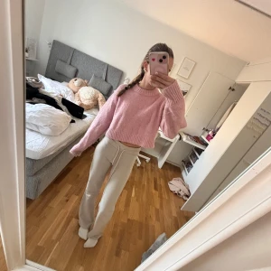 Rosa stickad tröja - Säljer en söt rosa stickad tröja med en croppad passform. Tröjan har långa ärmar och en rund halsringning, perfekt för en avslappnad stil. Den är både mysig och trendig, idealisk för kyligare dagar o sena sommarkvällar 