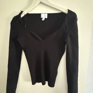 Svart ribbad tröja från H&M - Säljer en svart ribbad tröja från H&M med v-ringning och långa ärmar. Perfekt för en stilren look. Passar bra till både jeans och kjol.