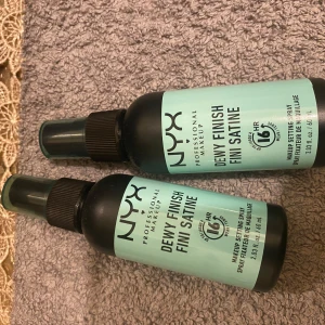 NYX Dewy Finish Setting Spray - NYX Professional Makeup Dewy Finish Setting Spray ger en fräsch och daggig look som håller i upp till 16 timmar. Perfekt för att fixera sminket och ge en långvarig finish. Flaskan är kompakt och lätt att ta med sig. 50kr båda