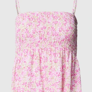 Blommig linnetopp med smockdetaljer - Söt och somrig linnetopp med smala axelband och smockdetaljer. Toppen har ett blommigt mönster i rosa och vita nyanser, perfekt för varma dagar. Hör av er vid frågor!💕