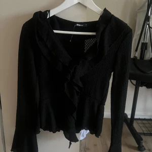 Svart topp/blus från Gina Tricot - Snygg svart blus/topp från Gina Tricot med volangdetaljer! Storlek S
