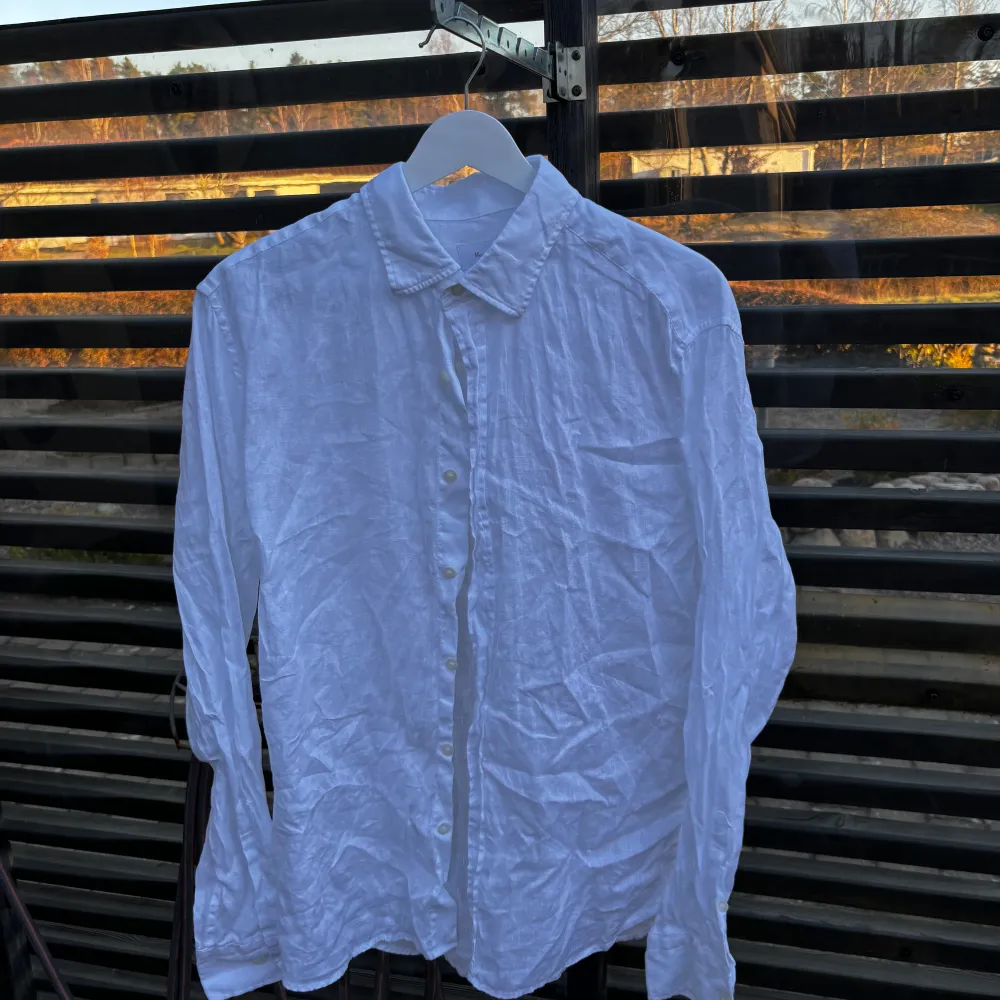 Säljer en stilren vit skjorta i 100% linne från Massimo Dutti. Skjortan har långa ärmar och knappar framtill. Perfekt för en avslappnad men ändå elegant look.. Paidat.