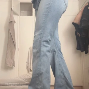 Ljusblå bootcut jeans med färgglada detaljer  - Säljer ett par ljusblå bootcut jeans från 157 med färgglada pärldetaljer på bakfickan. Eftersom de är för stora för mig. Jeansen har låg midja och klassisk femficksdesign. Perfekta för dig som gillar en retro vibe och vill sticka ut lite extra.